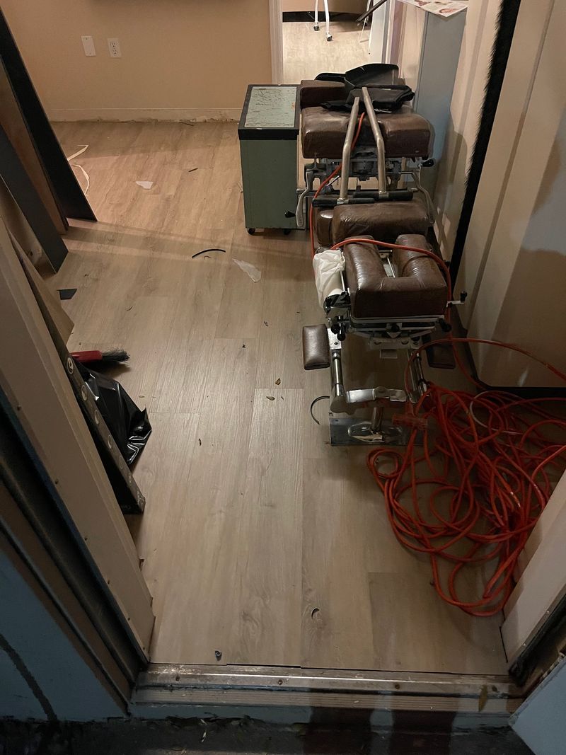 Clinic hallway with new light gray wood-look plank flooring and equipment