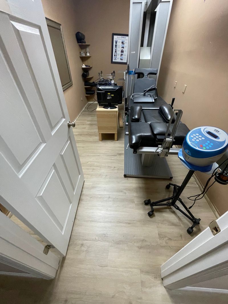 Treatment room with light gray wood-look plank flooring and a therapy table