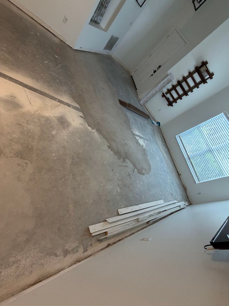 Living room slab patched and prepped with old baseboards removed