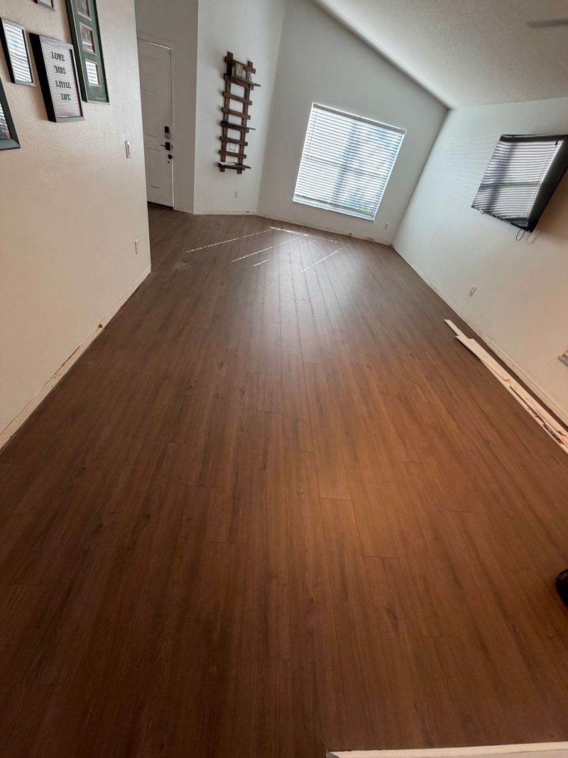 Long living room with dark walnut-tone wood-look plank flooring