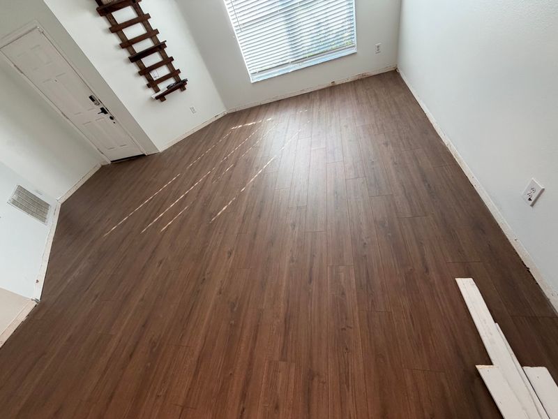 Bright living room with new dark brown wood-look plank flooring