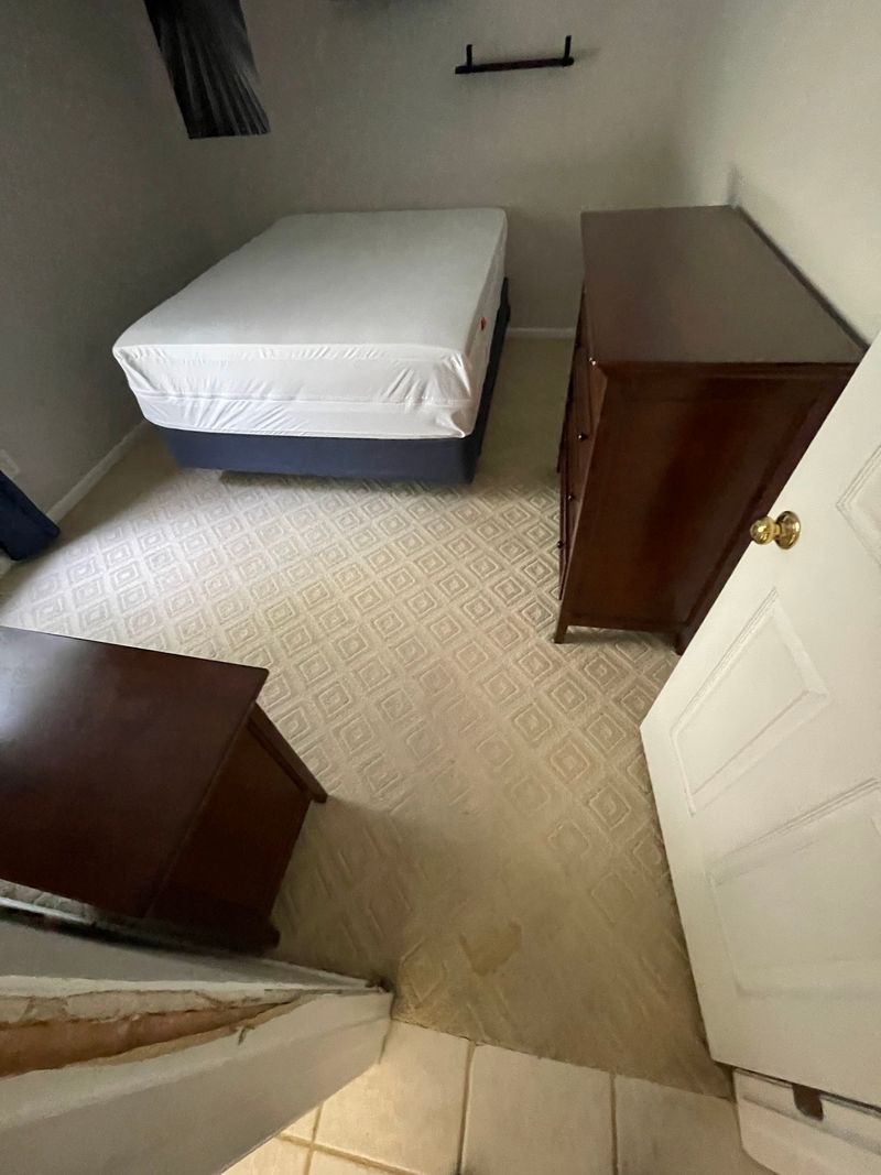 Bedroom with patterned beige carpet before replacement