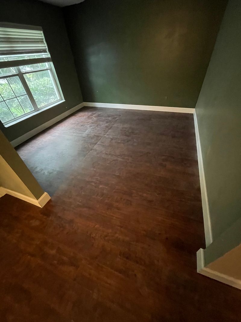 Empty room with dark brown laminate flooring and green walls