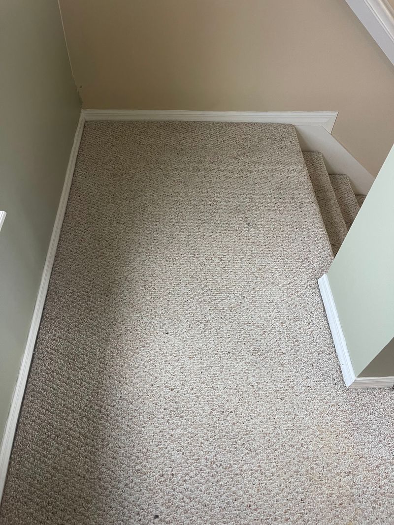 Upstairs landing covered in worn beige carpet before removal