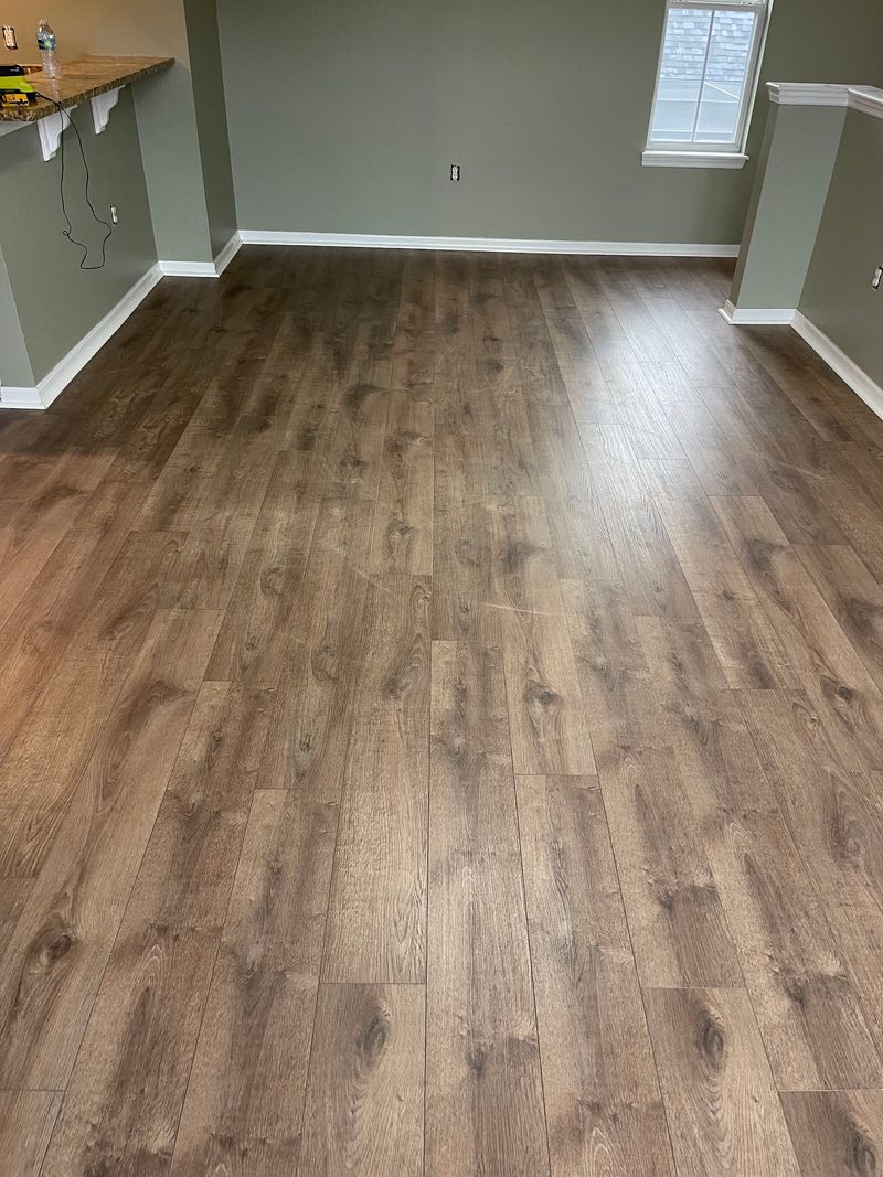Open upstairs room with new brown oak-look laminate and white baseboards