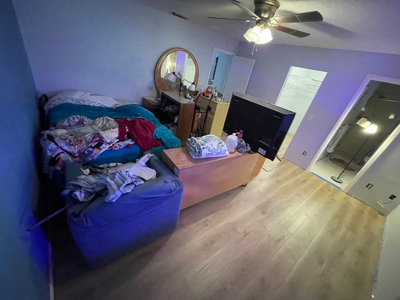 Bedroom with light oak laminate flooring under a ceiling fan