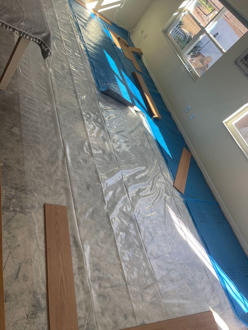 Living area slab with plastic sheeting and blue underlayment before the laminate goes down