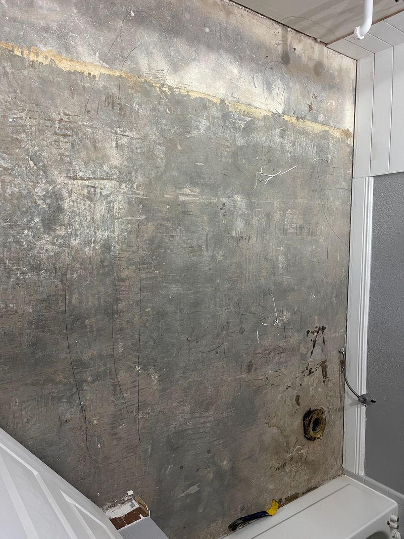 Bathroom stripped to the subfloor with the toilet removed