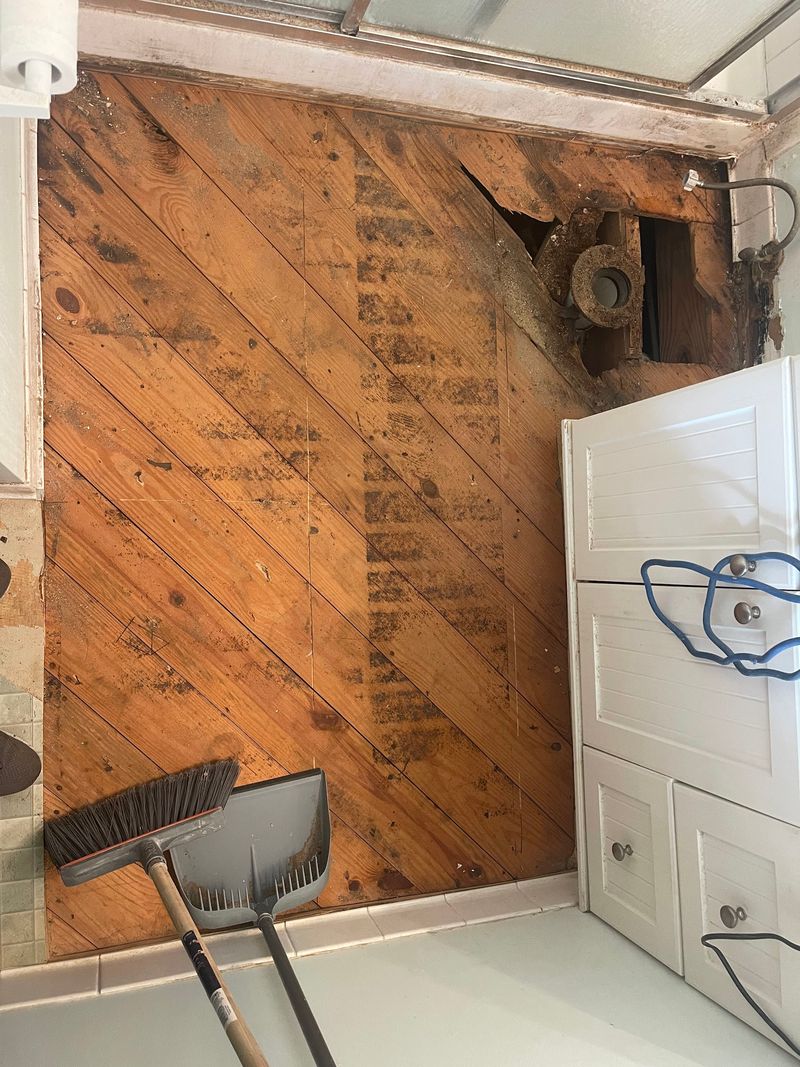 Bathroom subfloor boards exposed after removing the damaged flooring