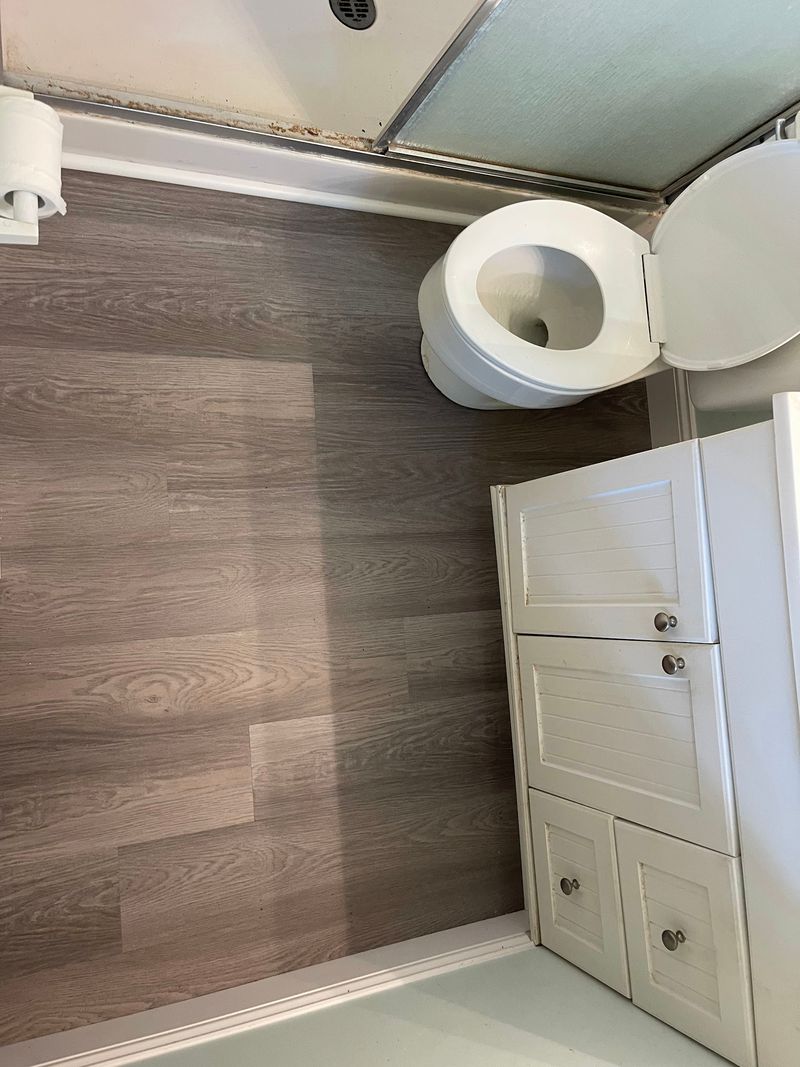 Overhead view of gray wood-look vinyl planks around the toilet and vanity