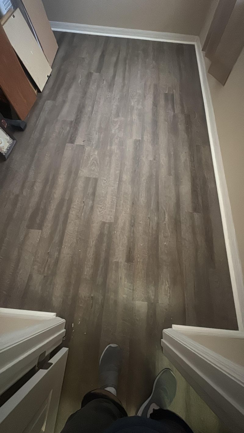 Long room finished in gray wood-look vinyl plank seen from the doorway