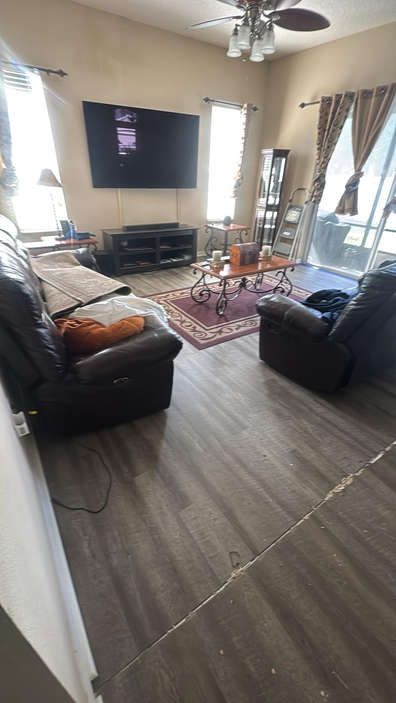 Living room with gray wood-look vinyl plank flooring and leather sofas