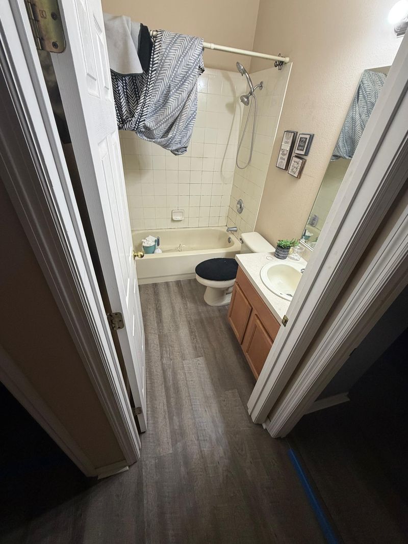 Bathroom with gray wood-look vinyl plank flooring seen from the doorway