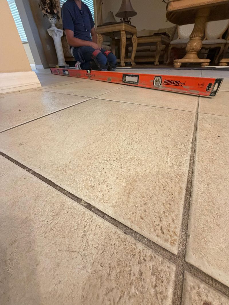 Old beige ceramic tile floor checked with a long level