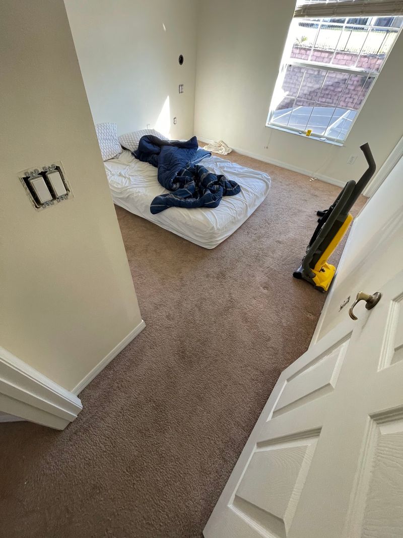 Upstairs bedroom with worn beige carpet before flooring replacement