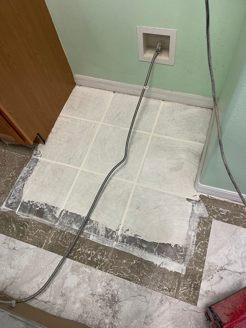 Laundry room with stone-look vinyl being laid over leveled old tile