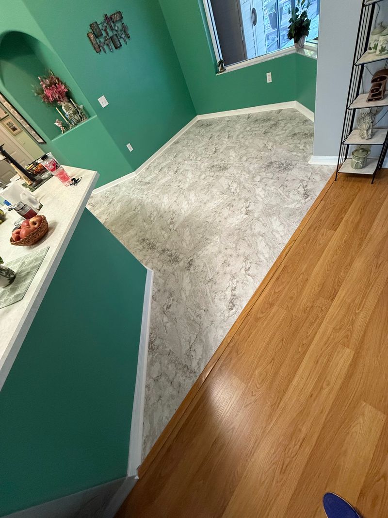 Stone-look vinyl floor meeting existing wood-look flooring at a hallway transition