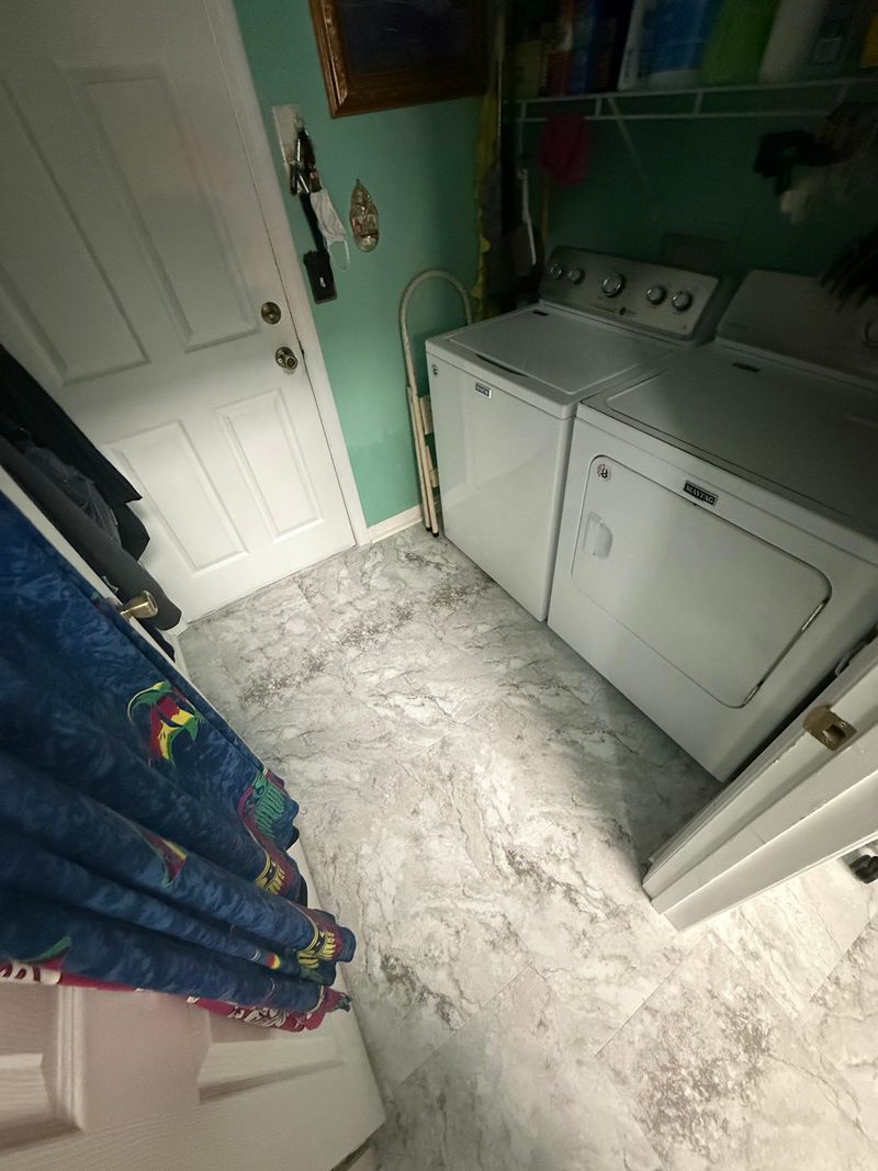 Laundry room finished with light gray stone-look vinyl flooring