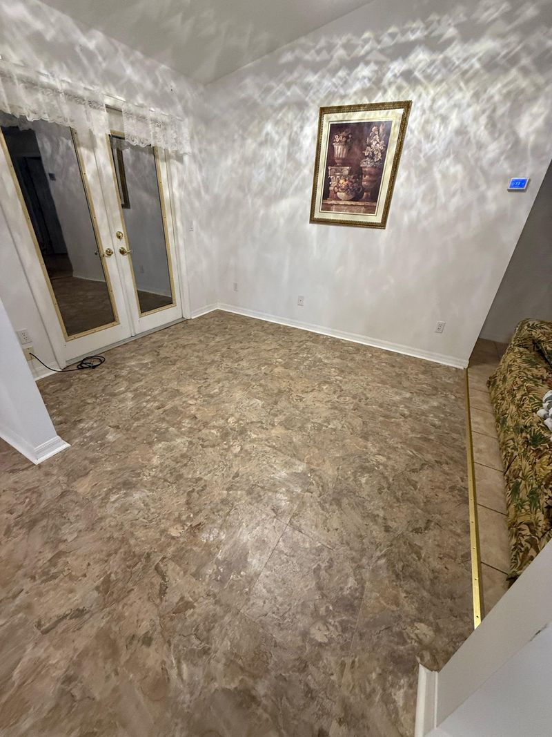Room with French doors and new beige mottled vinyl flooring