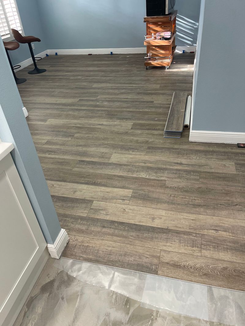 Doorway view of gray-brown vinyl plank flooring in an open room