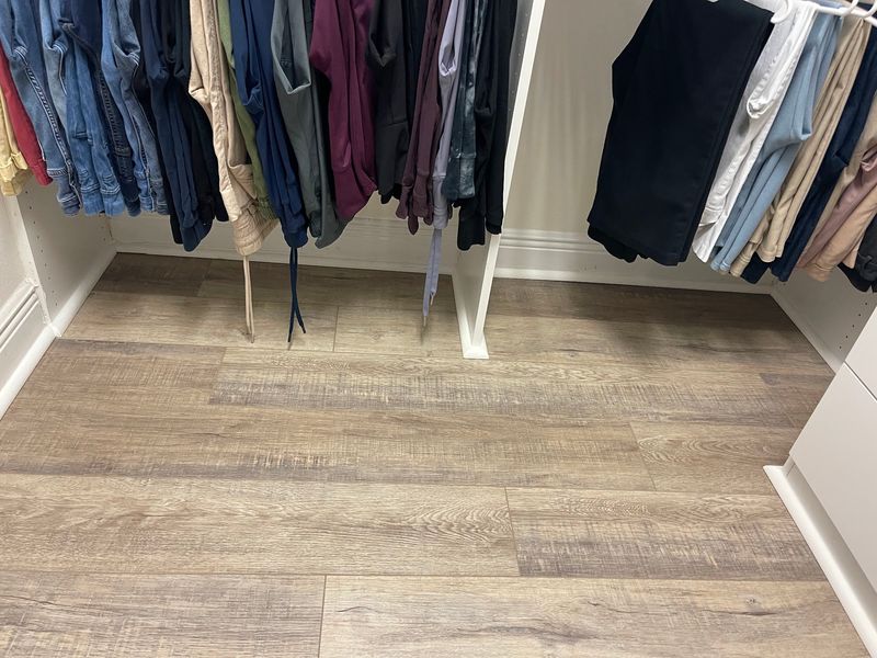 Walk-in closet finished with gray-brown wood-look vinyl plank