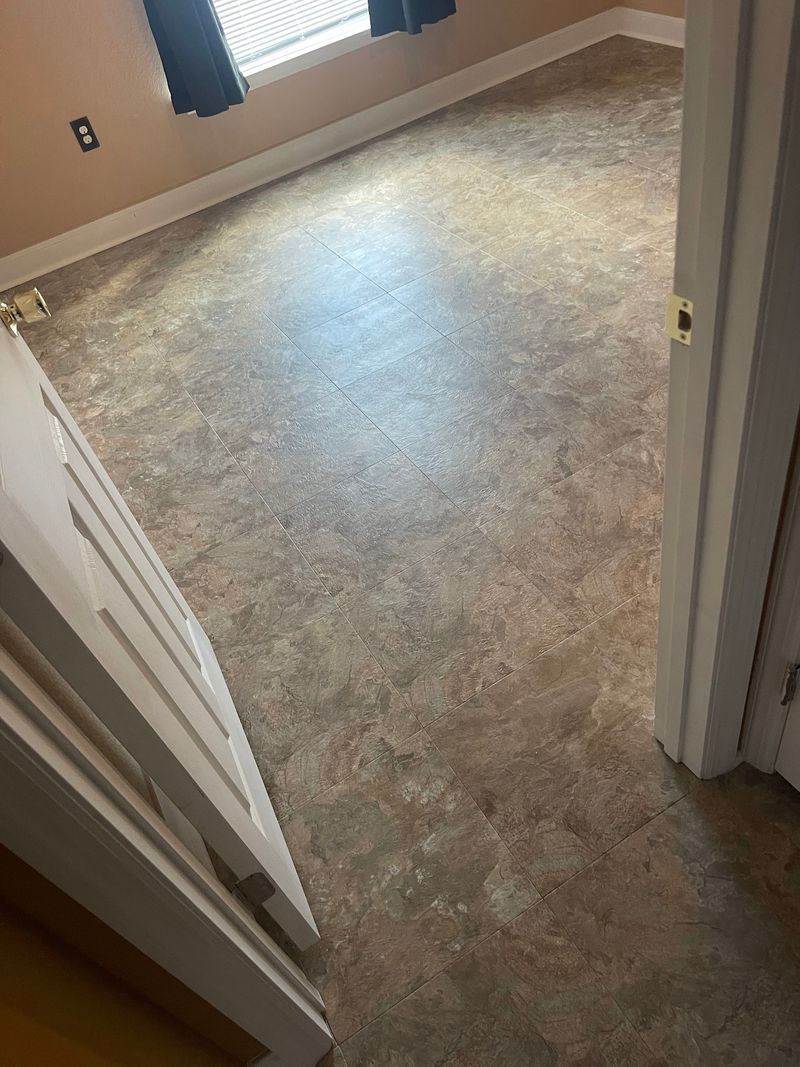 Bedroom with new stone-look vinyl flooring in warm gray tones