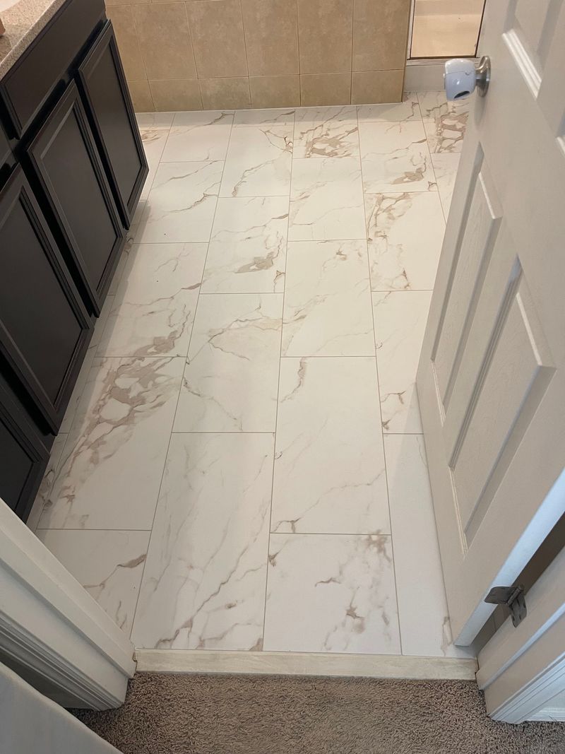 Bathroom with white stone-look vinyl flooring seen from the doorway