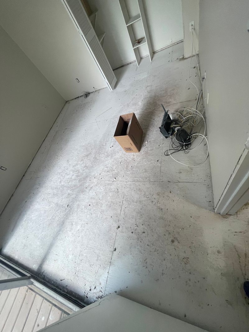 Empty room cleared down to the bare concrete slab before new flooring