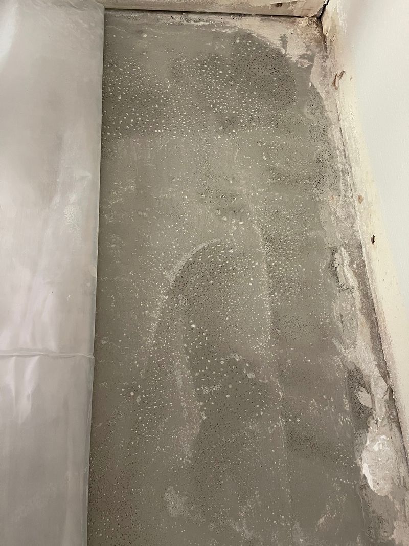 Concrete slab patched and leveled along a wall before installation