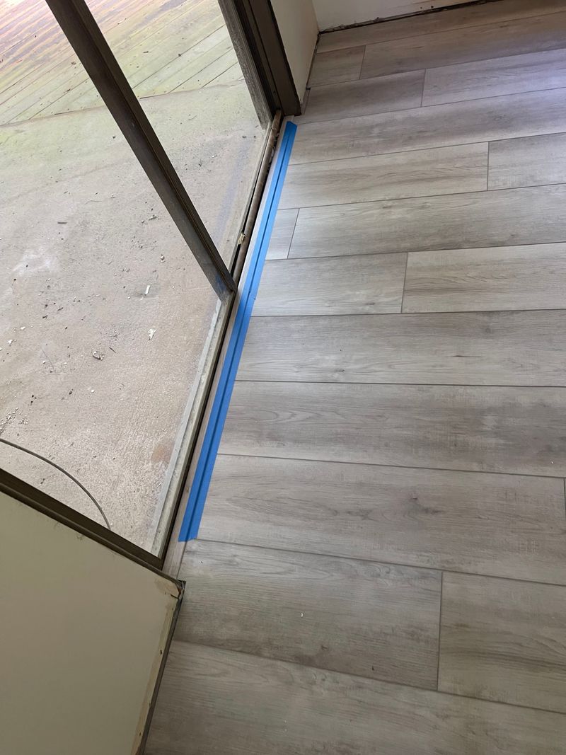 Light gray vinyl plank flooring meeting a sliding glass door