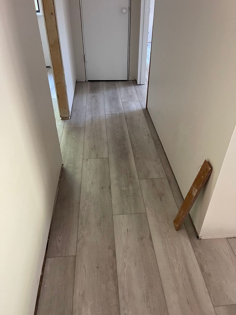 Hallway finished in light gray wood-look vinyl plank flooring