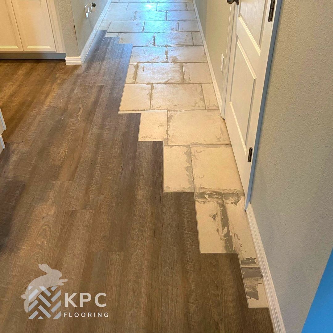 Wood-look vinyl plank installation in progress next to existing tile in a hallway